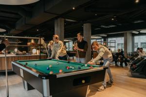 a group of men playing a game of pool at Next House Copenhagen in Copenhagen