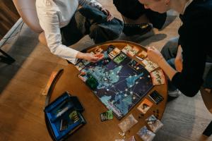 a group of people playing a board game on a table at Next House Copenhagen in Copenhagen