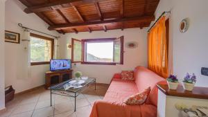 un soggiorno con divano e TV di Villa Monte Enrico - Pool And Whirlpool - Happy Rentals a Camporosso