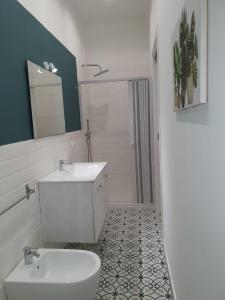 a white bathroom with a sink and a toilet at Airport Home TUREI & BRINGO Car Rental in Cinisi +17 photos