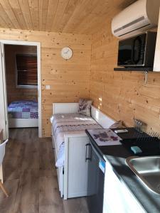 a kitchen with a bed in a room with a sink at Hetedhét Csillag Apartmanház in Bábonymegyer