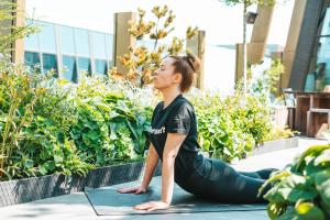 a woman doing a yoga pose in a garden at Next House Copenhagen in Copenhagen