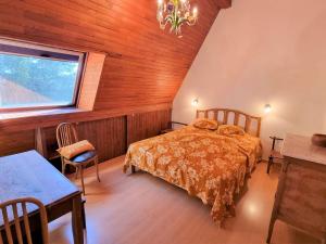 Un dormitorio con una cama y una ventana y una mesa. en Chalet spacieux 10 pers, 4 chambres, jardin, cheminée, animaux OK, ménage fin séjour option - FR-1-393-38, en Saint-Michel-de-Chaillol