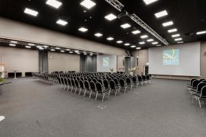 una sala de conferencias con sillas y una pantalla y una presentación en Quality Hotel Vänersborg, en Vänersborg