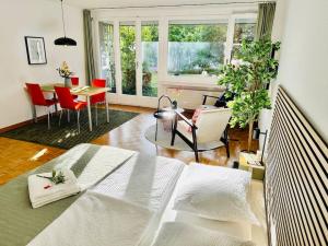 a bedroom with a bed and a table and chairs at New, central studio with garden terrace and much privacy in Zurich