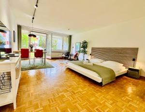 a bedroom with a large bed and a living room at New, central studio with garden terrace and much privacy in Zürich