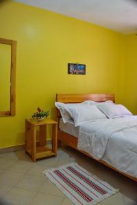 a bedroom with a bed and a yellow wall at Four seventy in Meru