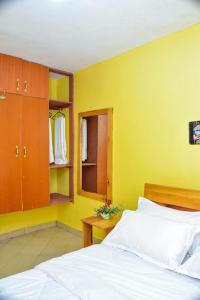 1 dormitorio con cama y pared amarilla en Four seventy en Meru
