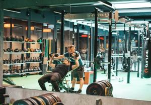 a man taking a picture of a man in a gym at Next House Copenhagen in Copenhagen