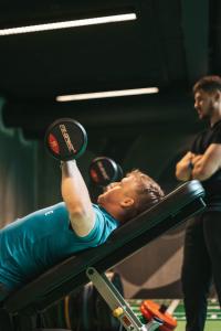 a man is laying on a bar in a gym at Next House Copenhagen in Copenhagen