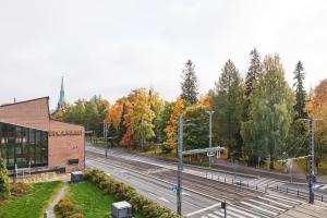 a building in front of a road with trees at Tasokas huoneisto kaupungin keskustassa. in Tampere