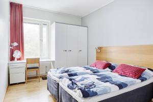 um quarto com uma cama grande e 2 almofadas vermelhas em Tasokas huoneisto kaupungin keskustassa. em Tampere