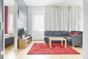 sala de estar con sofá azul y alfombra roja en Tasokas huoneisto kaupungin keskustassa. en Tampere