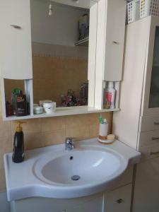 a bathroom with a white sink and a mirror at Anemone in Stavrákion