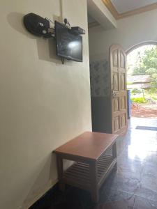 a room with a table and a tv on the wall at Casa De Calangute Inn in Calangute