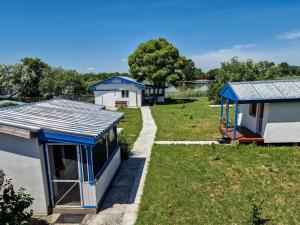 um grupo de casas num quintal com relva em Hanul Casa Alba Fehér Ház Fogadó em Periprava