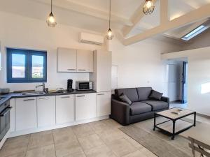 a kitchen and living room with a couch and a table at Golfe de Sagone Plage du Liamone Maison pieds dans l'eau in Casaglione +6 photos