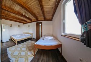 um quarto com duas camas e uma janela em Hanul Casa Alba Fehér Ház Fogadó em Periprava