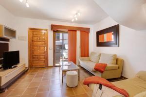 a living room with a couch and a tv at Residencial Maresia el Medano in El Médano