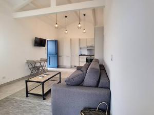 a living room with a couch and a table at Golfe de Sagone Plage du Liamone Maison pieds dans l'eau in Casaglione