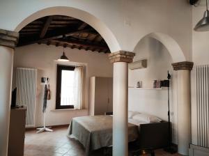 a bedroom with a bed in a room with columns at Via Zagarelli alle Mura 80 in Ravenna