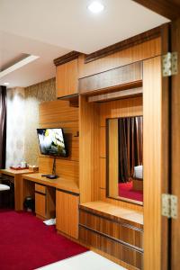 a hotel room with a desk and a television in a room at Grand Buana Lestari Hotel in Duku