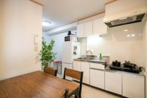 a kitchen with a wooden table and a dining room at 2023年4月オープン/新小岩駅から徒歩5分/収容人数5 in Tokyo
