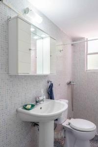 a bathroom with a sink and a toilet and a mirror at Private Voula Beach Suite in Athens