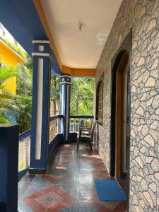 a porch with blue columns and a bench on a balcony at Casa De Calangute Inn in Calangute