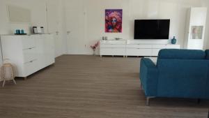 sala de estar con sofá azul y TV en Ferienhaus Urlaubshafen, en Bremerhaven