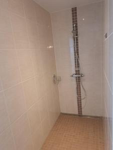 a bathroom with a shower with a tile floor at Haus Waldek in Herzlake