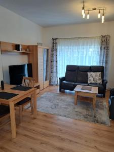 a living room with a black couch and a table at Haus Waldek in Herzlake