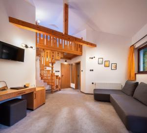 a living room with a couch and a staircase at Hotel Alfaresort Thermal Chiflika in Chiflik