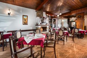 comedor con mesas y sillas y chimenea en Hotel Alfaresort Thermal Chiflika en Chiflik