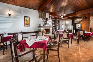 a dining room with tables and chairs and a fireplace at Hotel Alfaresort Thermal Chiflika in Chiflik