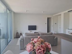 a living room with a couch and flowers on a table at Luxury apartment Lisbon in Lisbon