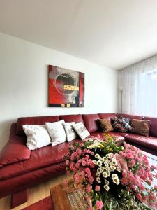 ヴィンターベルクにあるWinterberg Appartement 21068の茶色の革張りのソファ(花付)が備わるリビングルーム