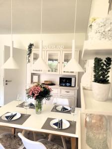 uma cozinha com armários brancos e uma mesa com flores em Winterberg Appartement 21116 em Winterberg