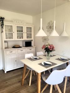 uma cozinha com uma mesa branca e cadeiras brancas em Winterberg Appartement 21116 em Winterberg