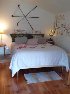 1 dormitorio con 1 cama con edredón blanco grande en Aux grès des moisonettes en Notre-Dame de la Mer