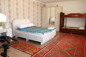 Schlafzimmer mit einem Bett und einem roten Teppich in der Unterkunft Almaz Guesthouse Naryn in Orto-Saz