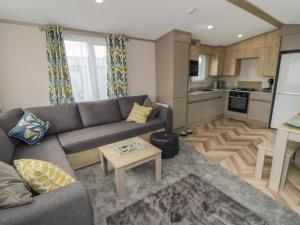 a living room with a couch and a kitchen at Walkers Rest in Ganton