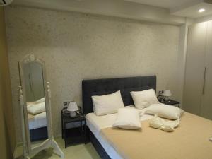 una camera da letto con un letto con cuscini bianchi e uno specchio di Villa Gusta a Thólos