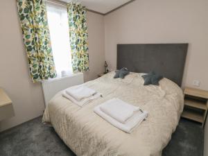 a bedroom with a bed with towels on it at Walkers Rest in Ganton
