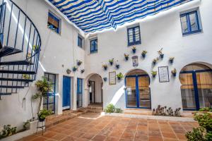 a courtyard of a building with blue doors and windows at Casas Caballerizas Mezquita 1 y 3 HAB in Córdoba