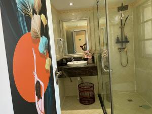 ein Bad mit einer Dusche und einem Waschbecken in der Unterkunft Wesley Rosegarden 庐山卫斯里玫瑰园别墅 in Jiujiang
