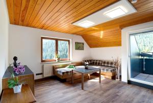 a living room with a wooden ceiling and a table at Haus Erika Ferienwohnung 2 in Bad Teinach-Zavelstein