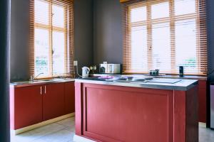 a kitchen with red cabinets and a red counter top at Villa Margherita in Swakopmund