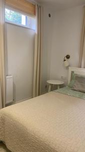 a bedroom with a large bed and a window at Apartament Vintage in Mrągowo