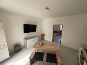 ein Wohnzimmer mit einem Tisch und einem Flachbild-TV in der Unterkunft Wohnglück in Herten